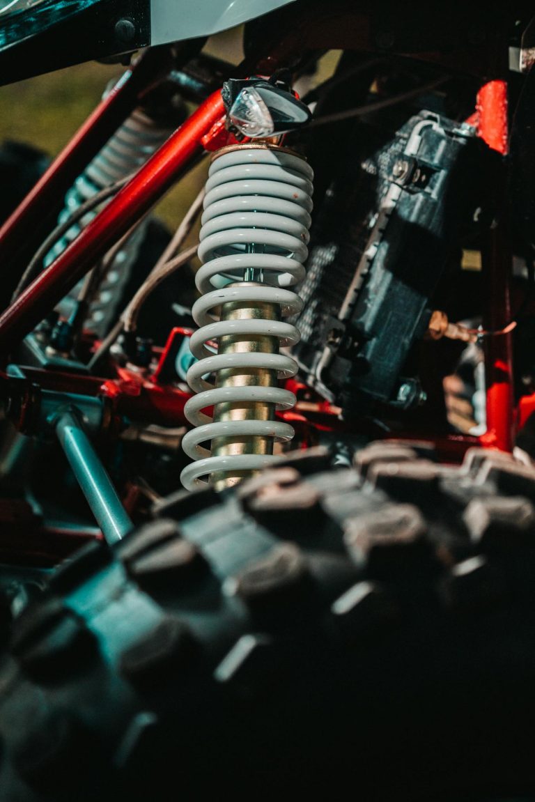 Detailed view of an ATV's coil spring suspension highlighting mechanical design and rugged build.